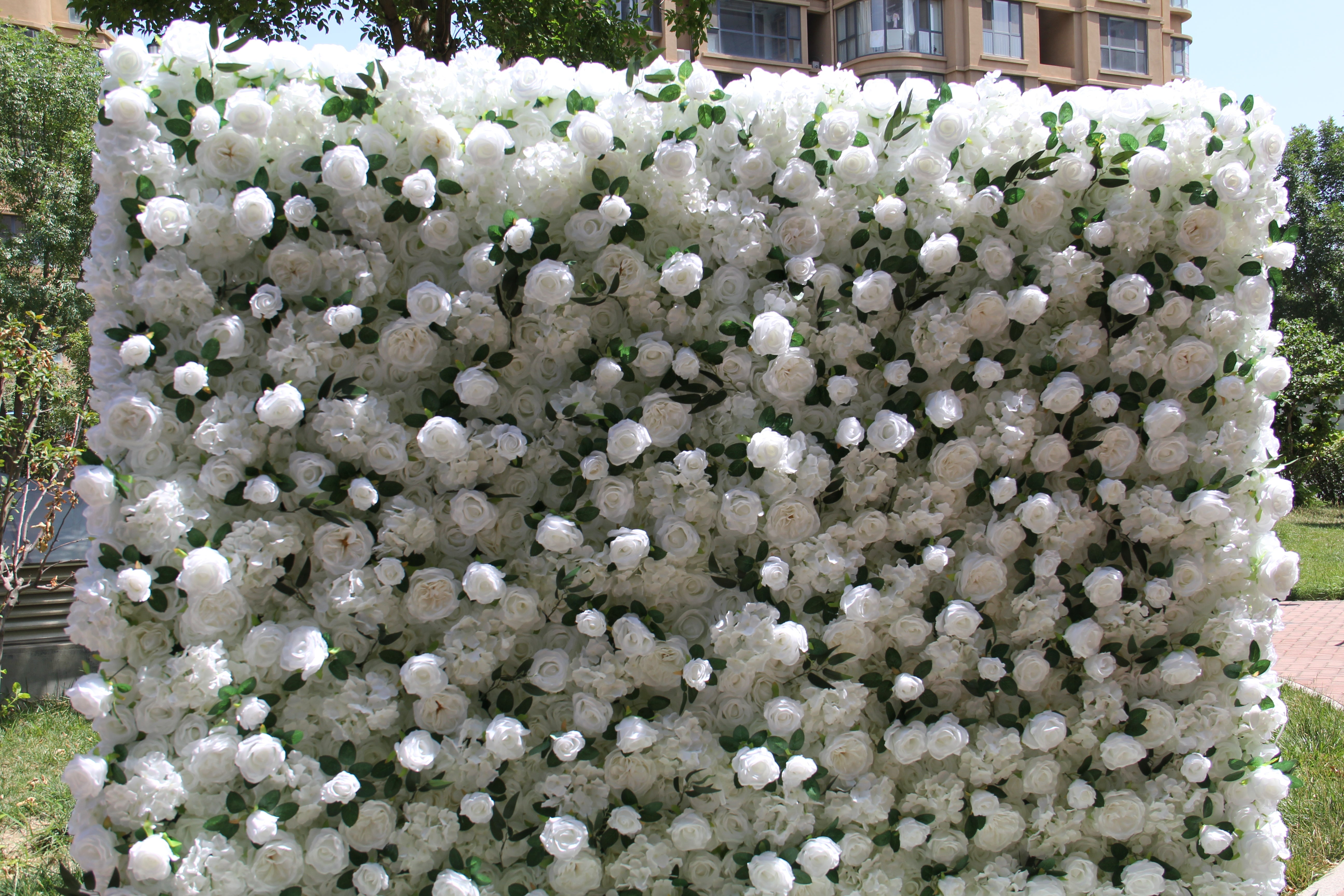 The white peony & green rose flower wall's detailed view highlights its vibrant, realistic shapes and fabric backing.