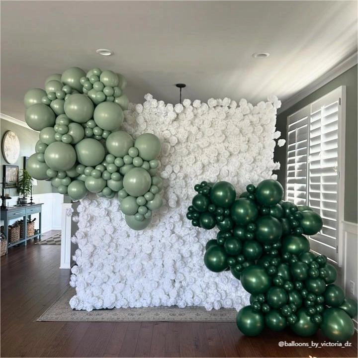 White flower wall with balloon decorations.