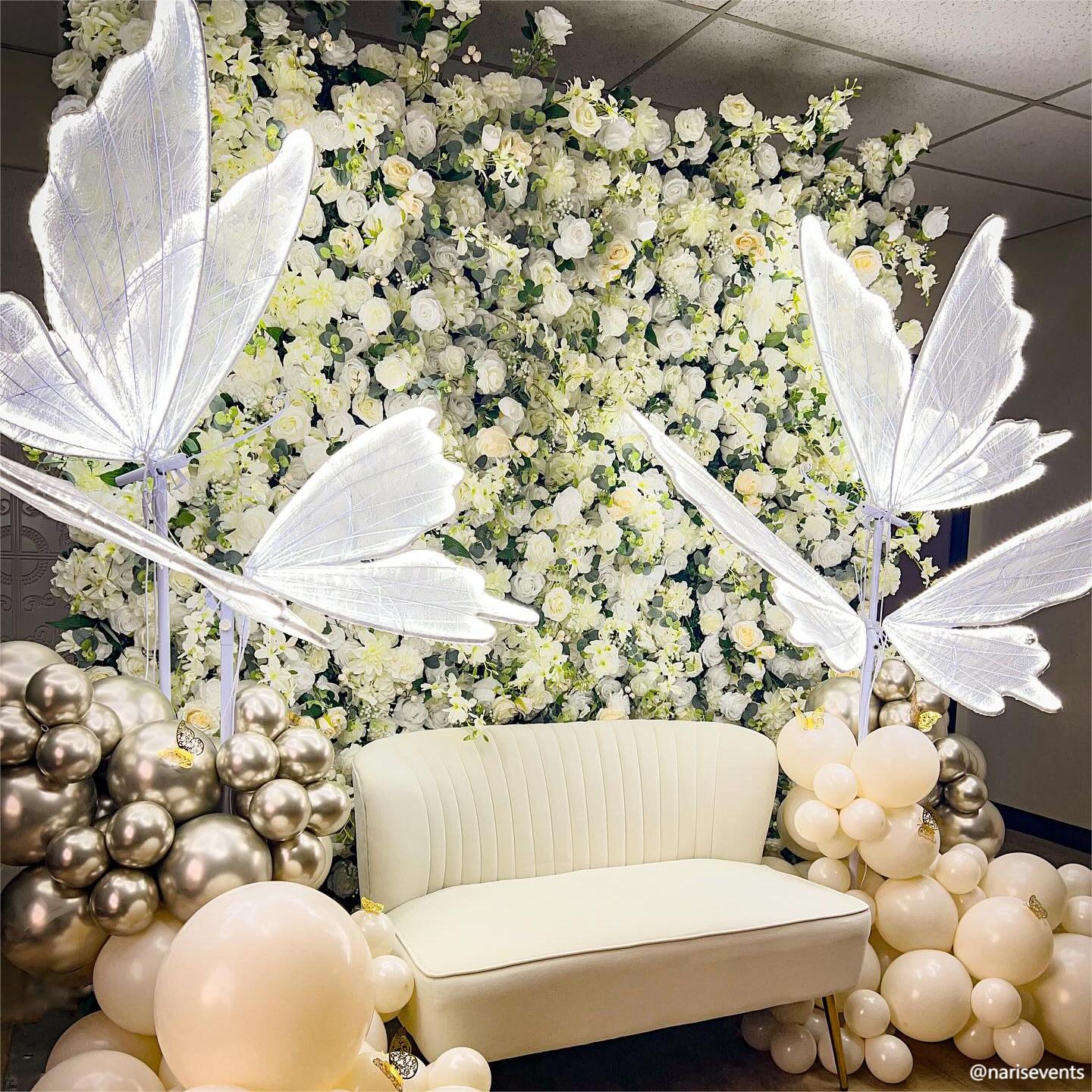 Butterfly ornaments make the white champagne flower wall looks more sophisticated and elegant.