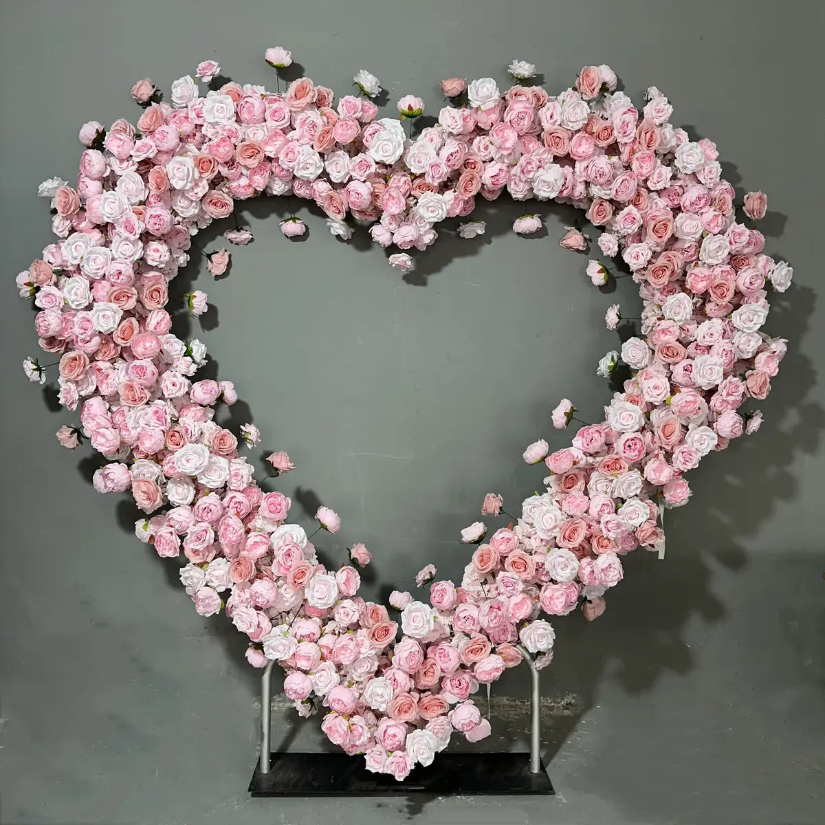 Pink heart-shaped artificial roses flower arch.