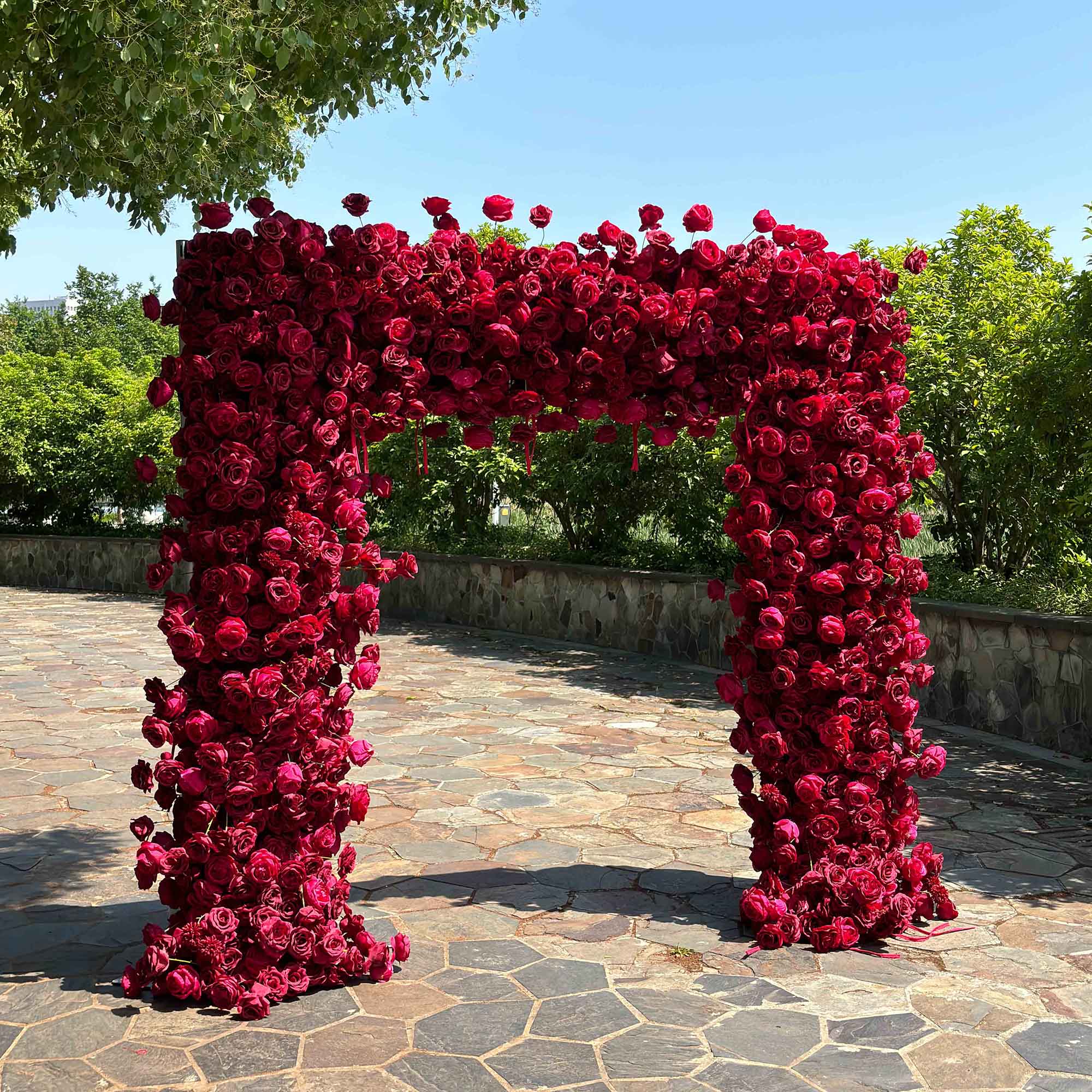The wine red roses flower arch's side view boasts realistic shapes and a fabric backing.