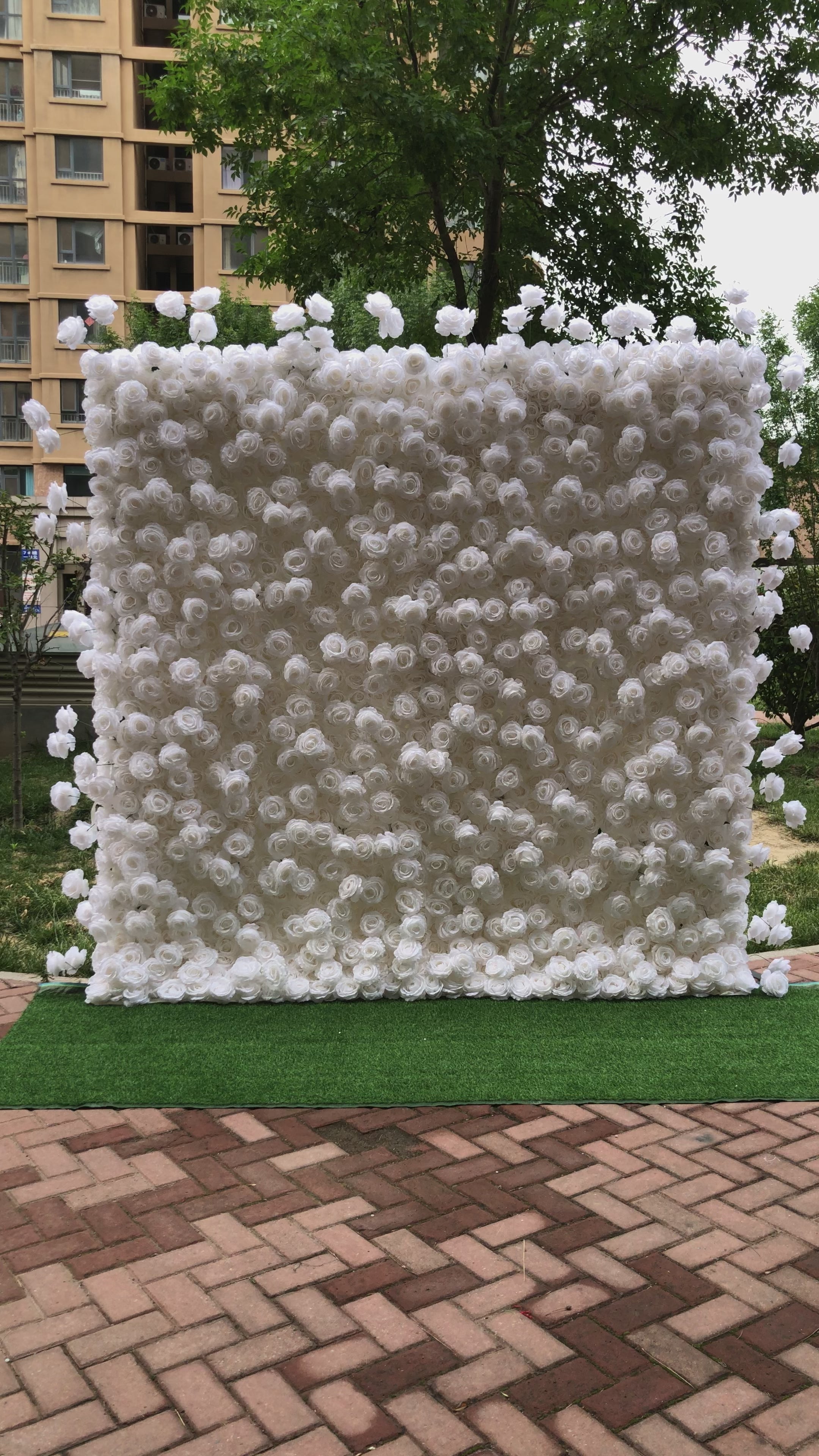 The pure white rose fabric flower wall looks vivid and lifelike.